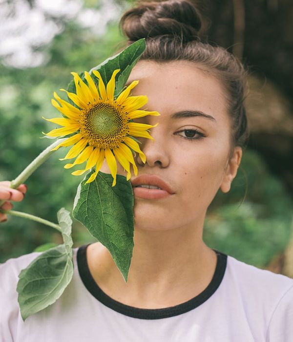 Woman in a calm pose surrounded by soft green light.